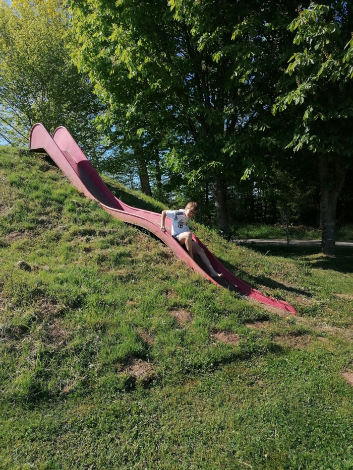Kind auf der roten Rutsche am Spielplatz des Campingplatzes Waldeck