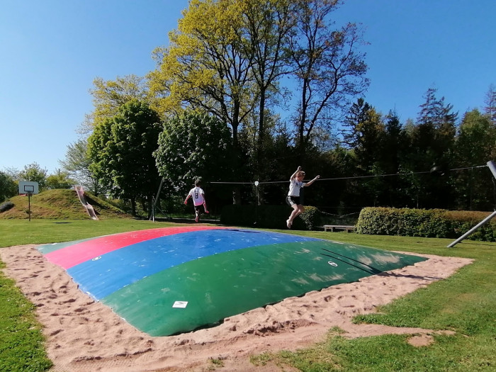 Kinder auf dem Hüpfkissen am Spielplatz des Campingplatzes Waldeck
