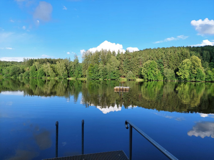Blick vom Badesteg auf den Häslestausee mit Schwimmplattform am Campingplatz Waldeck