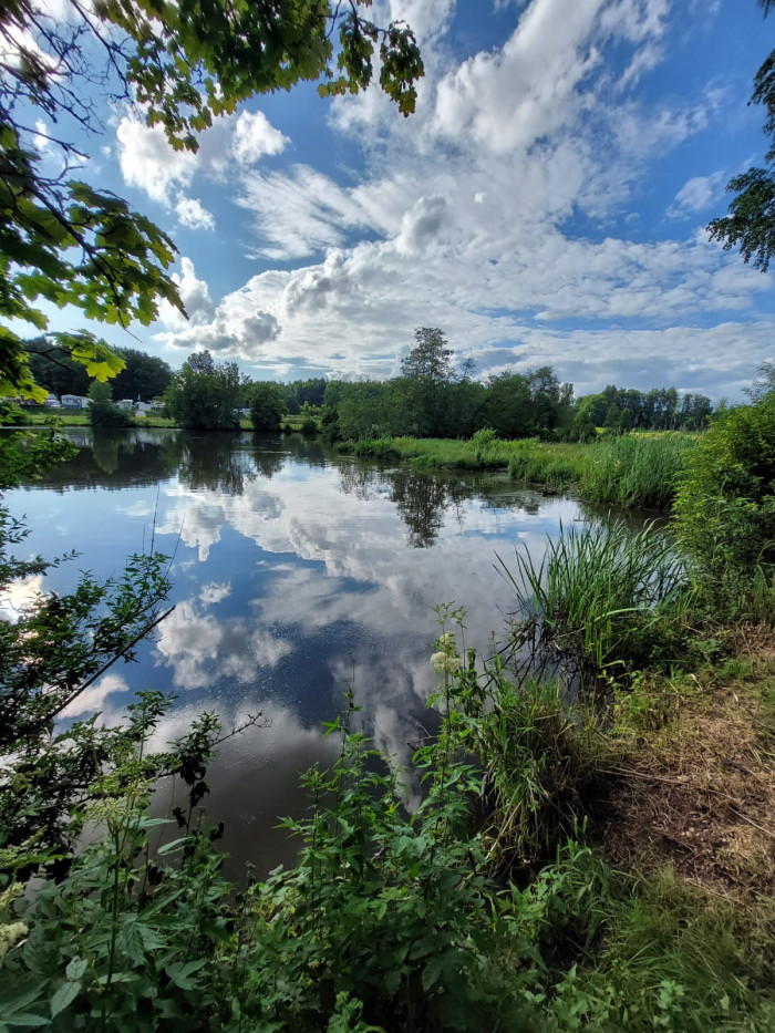 Wolken spiegeln sich im stillen Häslestausee am Campingplatz Waldeck